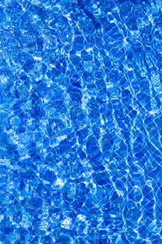 Blue tiles pool with ripple water reflection as a summer background