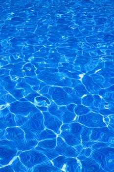 Blue tiles pool with ripple water reflection as a summer background