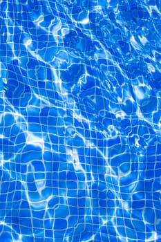 Blue tiles pool with ripple water reflection as a summer background