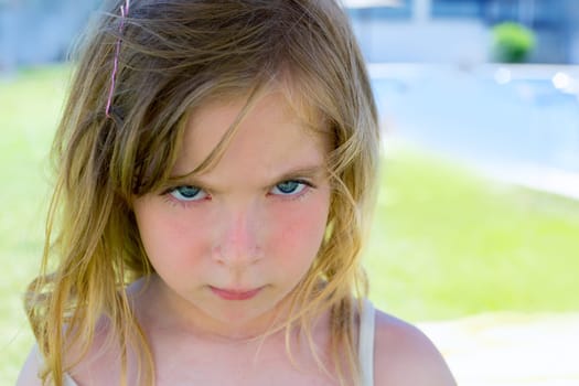 Angry blond children girl portrait looking at camera