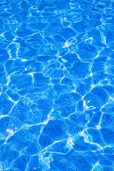 Blue tiles pool with ripple water reflection as a summer background