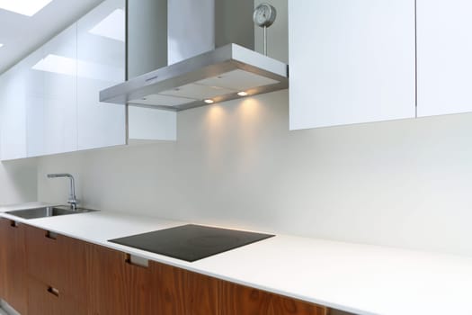 Actual modern kitchen in white and walnut wood interior house