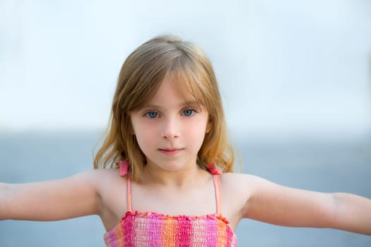 Blond kid girl open arms in outdoor with sundress