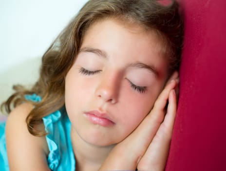 beautiful brunete kid girl sleeping hands together on red sofa