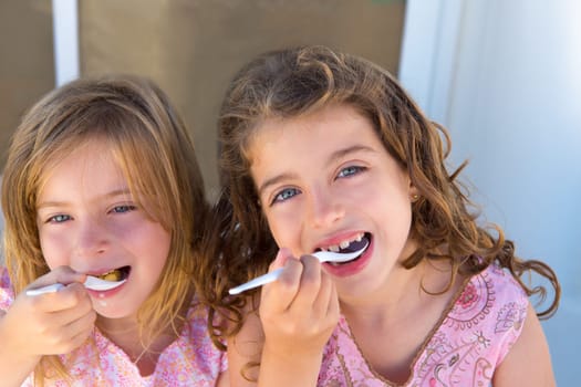 Blue eyes kids sister girl eating breakfast with spoon