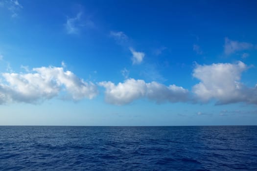 cumulus clouds in blue sky over ocean water horizon