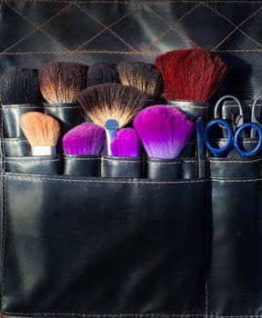 brushes scissors and tools of makeup artist in black leather belt set