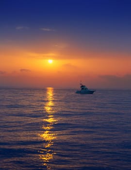 fisherboat in horizon on sunset sunrise at sea with sun reflection in blue water