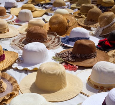 Hats display on a street market outdoor under sunny summer light