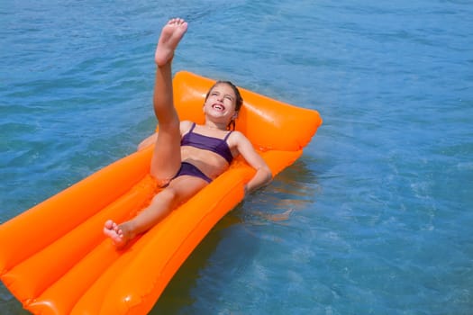 children kid girl playing in beach shore with orange floating lounge