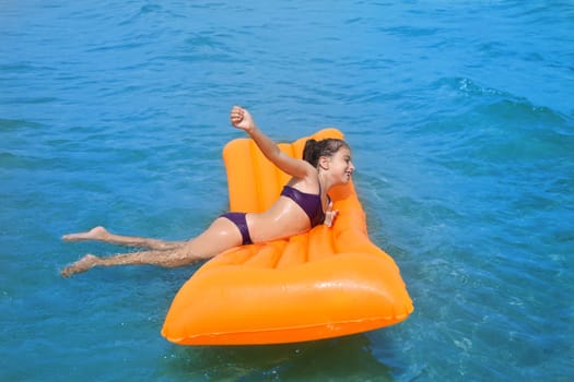 children kid girl playing in beach shore with orange floating lounge