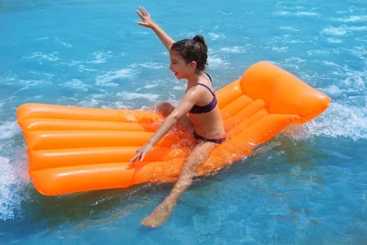 children kid girl playing in beach shore with orange floating lounge