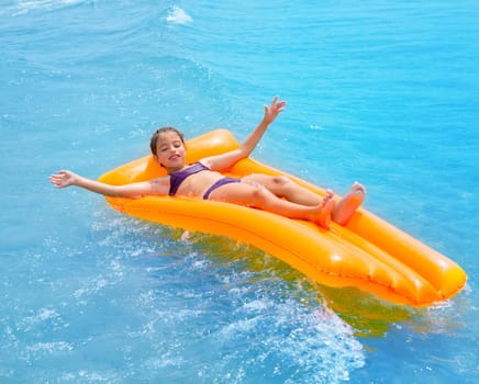 children kid girl playing in beach shore with orange floating lounge