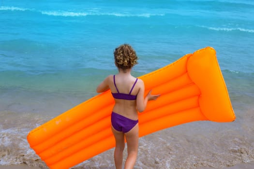 children kid girl playing in beach shore with orange floating lounge