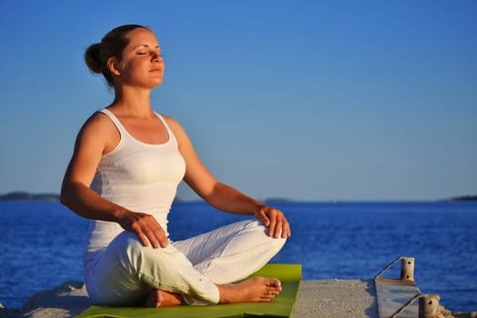 Young woman during yoga meditation on the beach