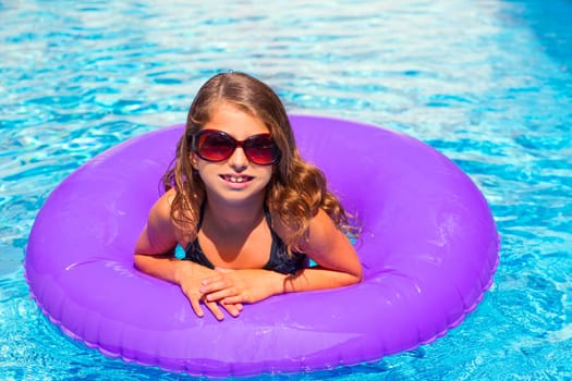 bikini kid girl with fashion sunglasses with purple inflatable pool ring