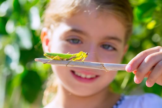 scientific naturalist biologist kid girl looking praying mantis insect closeup
