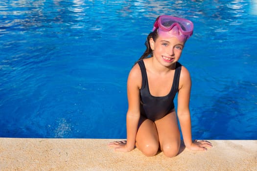 Blue eyes kid girl on knees on blue pool poolside with snorkel pink glasses