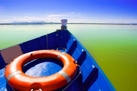 Blue boat sailing in Albufera lake of Valencia in a sunny blue sky day