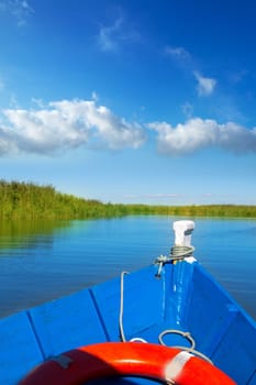 Blue boat sailing in Albufera lake of Valencia in a sunny blue sky day