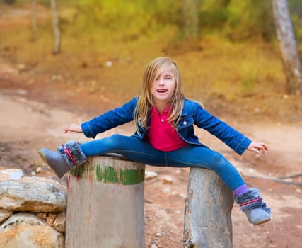 Open legs children playing girl or tree trunks at forest outdoor