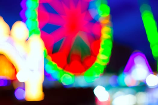 colorful ferrys wheel fairground night lights over blue sky
