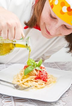 smiling chef garnish an Italian pasta dish