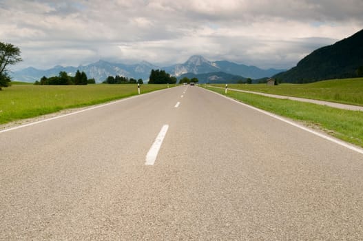 Perspective view along a country road in the direction of travel in the Ostallgäu near the city of Füssen