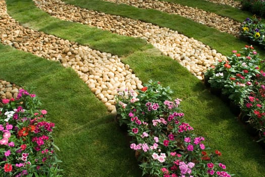 Neatly laid decorative bands of lawn, pebbles and flower beds