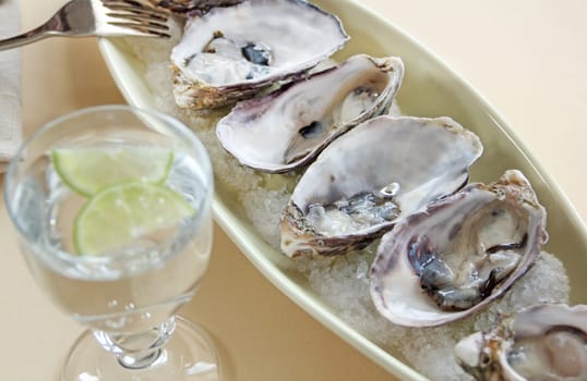 A fresh serving of natural oysters with a chilled lime drink.