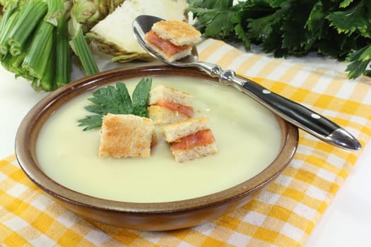 a bowl of cream of celery soup with salmon croutons