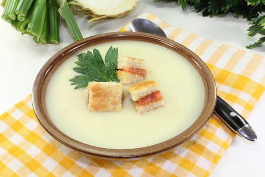 a bowl of cream of celery soup with salmon croutons