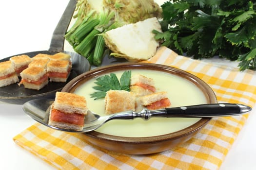 a bowl of cream of celery soup with salmon croutons