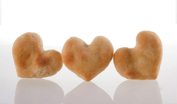 Three heart-shaped cookies isolated and its reflection on white background.  Included clipping path, so you can easily cut it out and place over the top of a design.