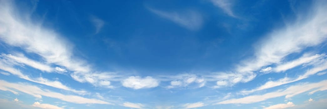 White fluffy clouds on a blue sky background. Wide screen