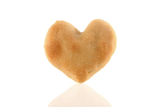 Single Heart-shaped cookie isolated with reflection on white background.  Included clipping path, so you can easily cut it out and place over the top of a design.