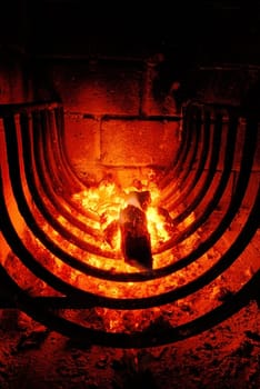 Fire and embers of a barbecue inside a brick oven