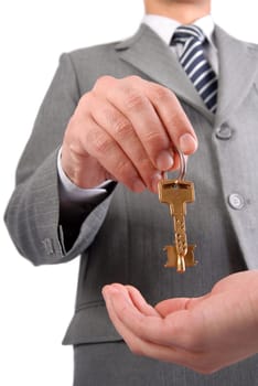 Businessman handing a key to success over a woman palm isolated on white.