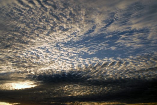 Sun light passes through dramatic cirrus clouds. Sunrise sky background.