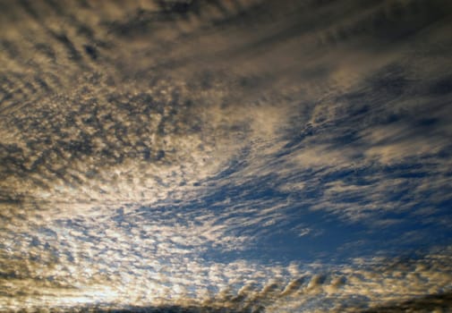 Sun light passes through dramatic cirrus clouds. Sunrise sky background.