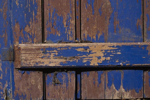 Vintage wooden door with the grunge violet paint. Useful as background for design works.