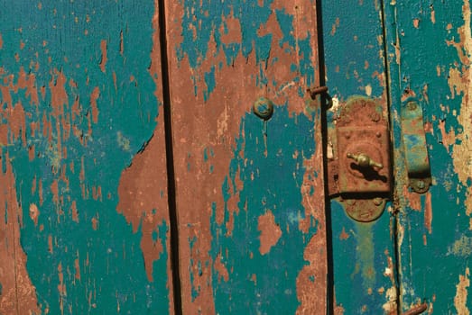 Vintage wooden door with the grunge lock and paint close up. Useful as background for design works.