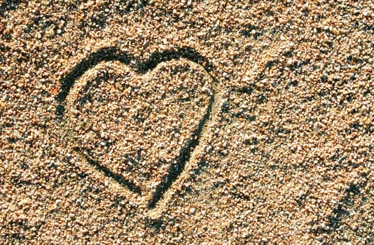 Heart  drawn in the sand. Love background