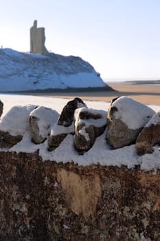 a seasonal snow covered stone wall view of castle and atlantic ocean in ireland