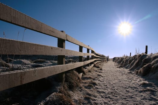 frosty winters view at ballybunion cliffside walk with bright sun and fence