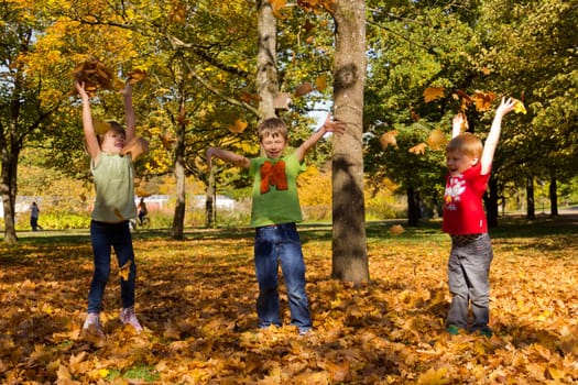 Children playing with leaves in autumn