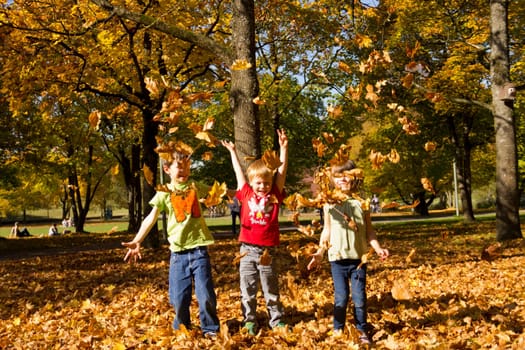 Children playing with leaves in autumn