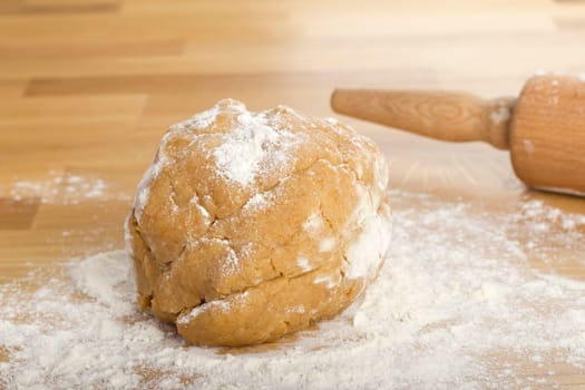 Dumpling on flour with rolling pin in background