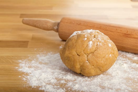 Dumpling on flour with rolling pin in background