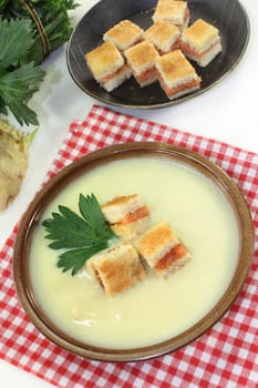 a bowl of cream of celery soup with salmon croutons